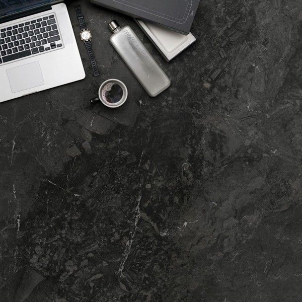 Bureau en pierre noire avec une tasse de café et un ordinateur dans le coin gauche en haut